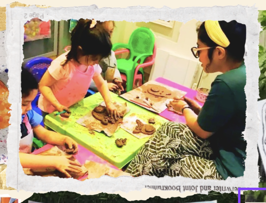 Daniela helping children make clay figures at a low table