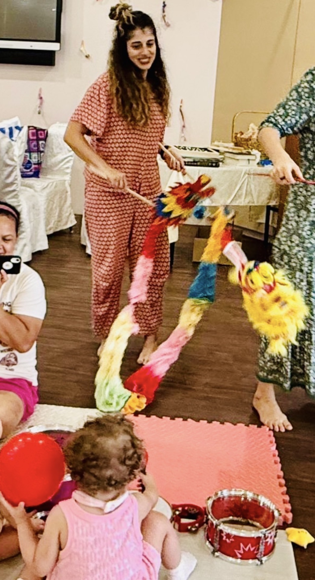 Daniela running a puppet session with a toddler on a foam mat